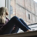 kobieta patrząca przez okno