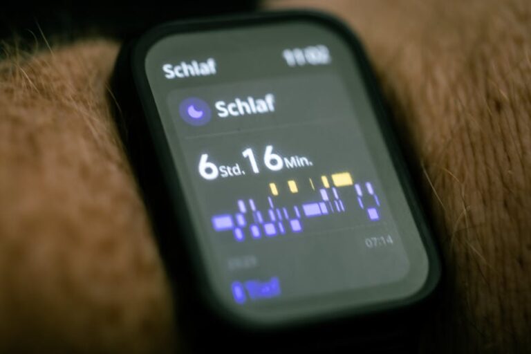 Zbliżenie na wyświetlacz smartwatcha pokazujący statystyki przespanej nocy w języku niemieckim.