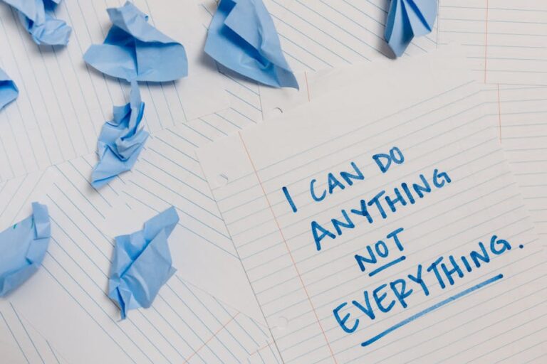 Kartka z napisem „I can do anything not everything” i zmięty niebieski papier.