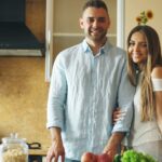 uśmiechnięci kobieta i mężczyzna stojący w kuchni