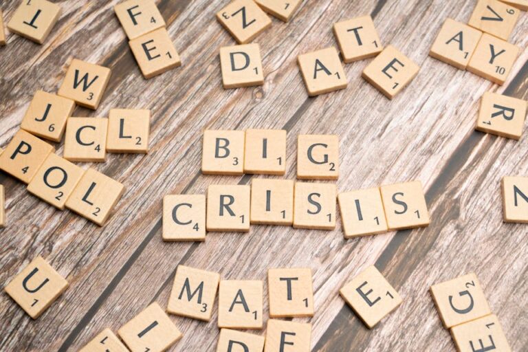 Drewniane kafelki z gry Scrabble układające się w słowa „BIG CRISIS”.