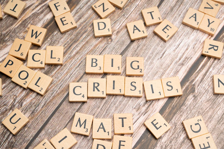Drewniane kafelki z gry Scrabble układające się w słowa „BIG CRISIS”.