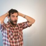 mężczyzna trzymający się za głowę