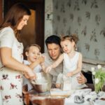 rodzice z dwójką dzieci spędzający razem czas w kuchni